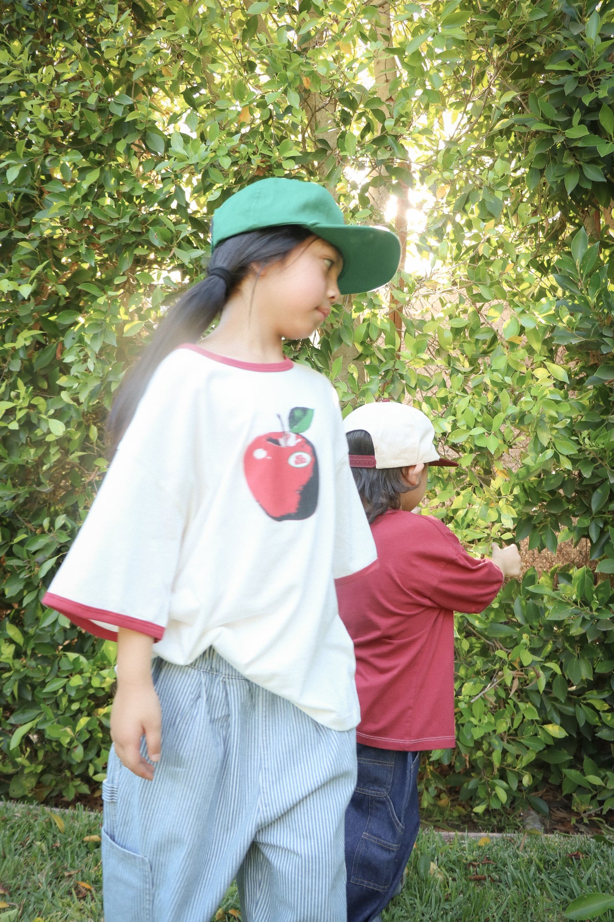 Child wearing white Good Apple ringer T-shirt