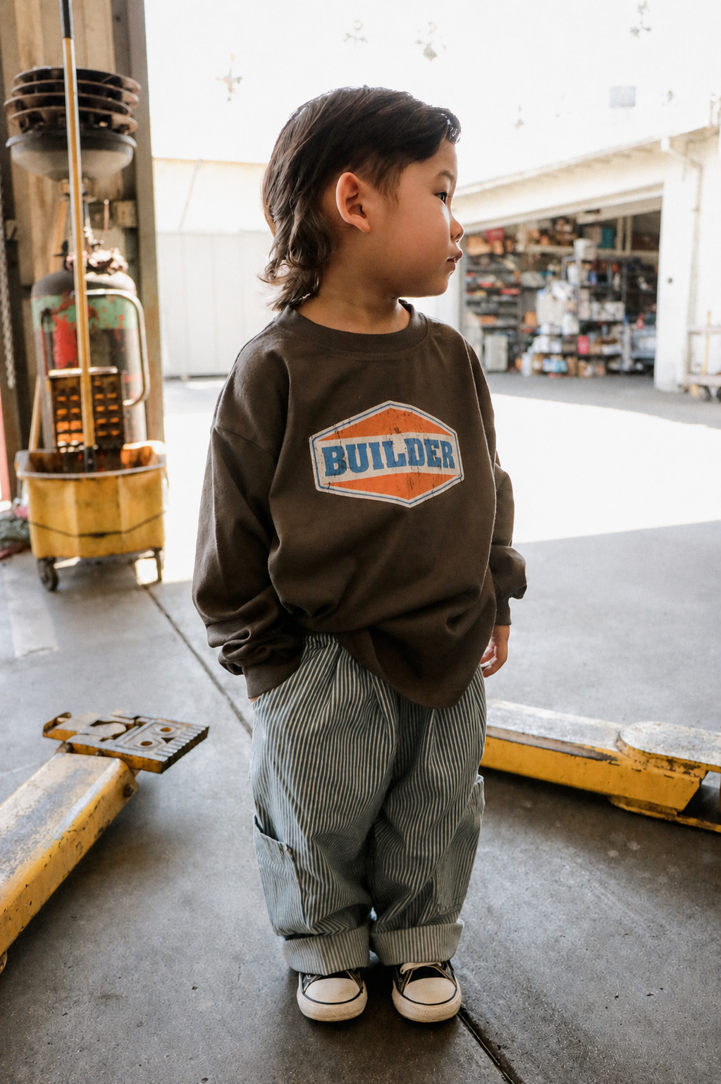 Child wearing dark grey oversized Builder long-sleeve T-shirt