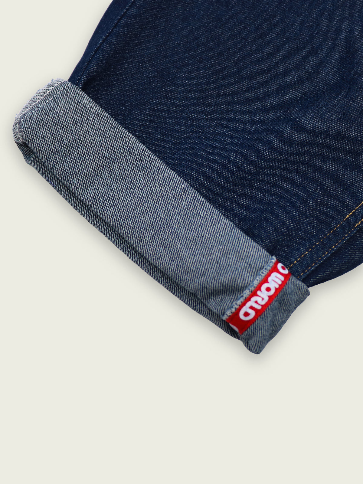 Cuffed GOO WORLD Workshop Jeans showing logo tape